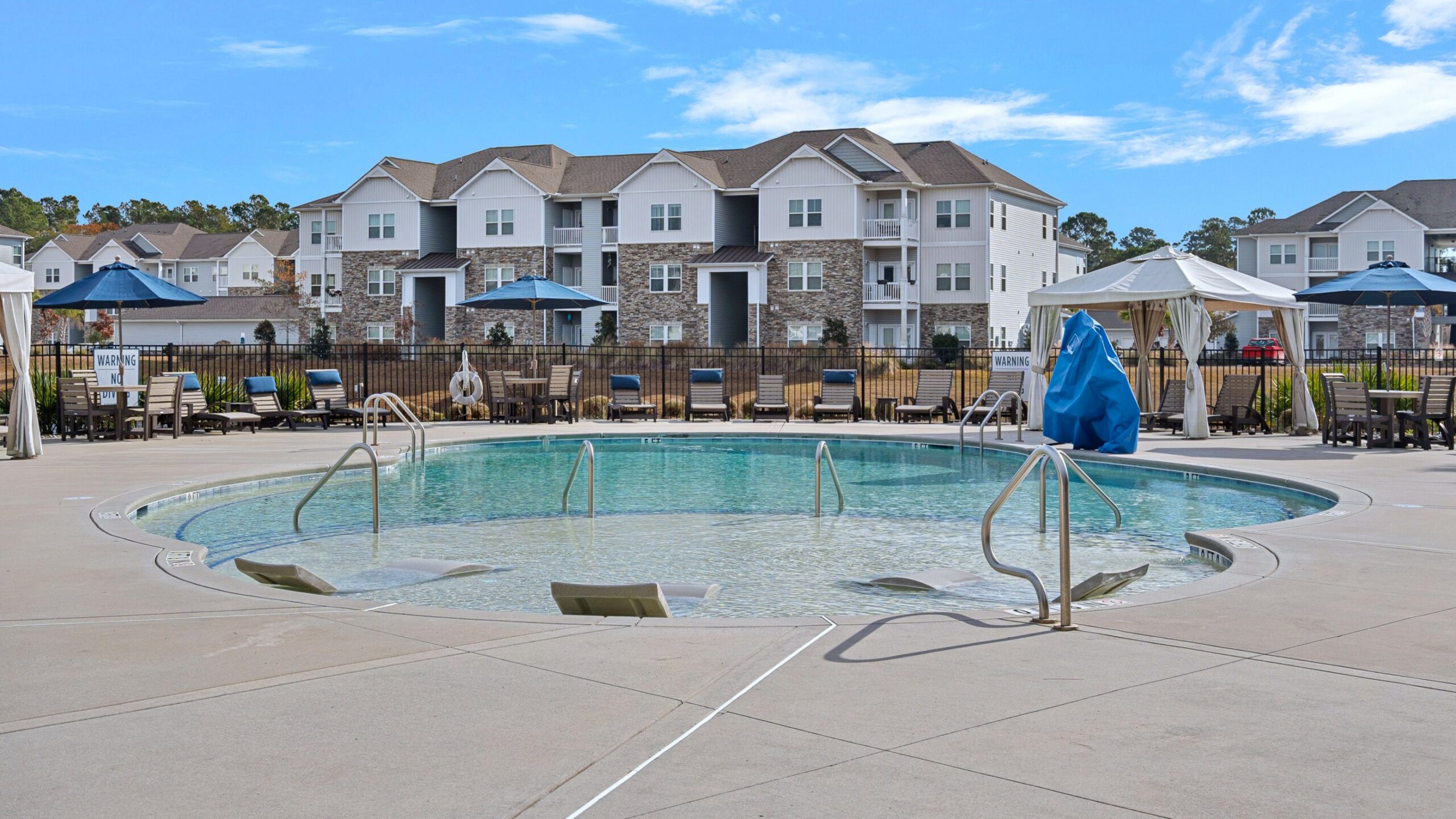 Hawthorne at the Bend uxury outdoor pool with in-pool lounge chairs and surrounding seating